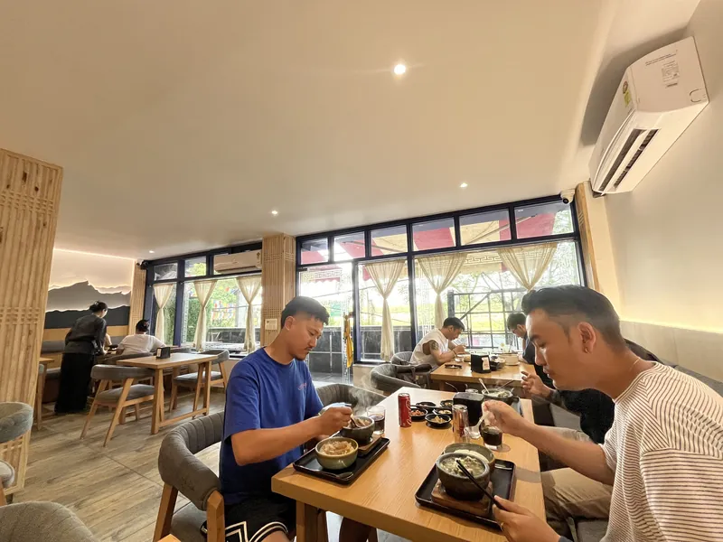 Guests eating at a window table in the Sarang dining room